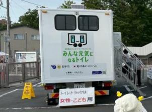 トイレトラックの後部に女性と子供用ですと看板が設置されている