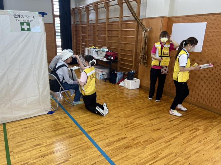 体調不良者用スペースで救護班の職員が避難者の検温をしている写真