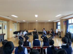 中学校の音楽室で芸大生5人が生徒の前で演奏している様子