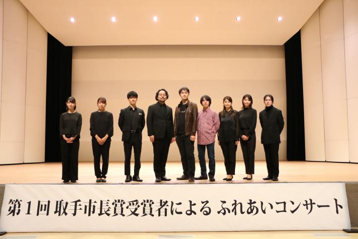 ステージ上で出演者が並んで立っている写真