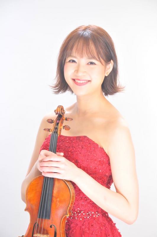 二上りか子。赤いドレスを着てバイオリンをもった女性がにっこり微笑んでいる。