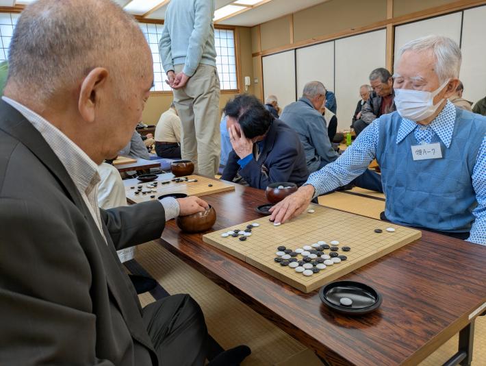 たくさんの男性が囲碁の対局をしている様子