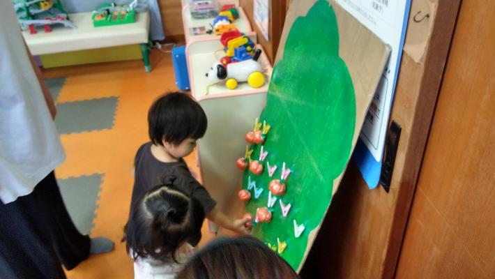 子どもが手作りの柿をとっている写真