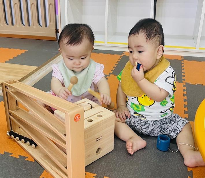 2人の赤ちゃんが積み木で遊んでいる写真