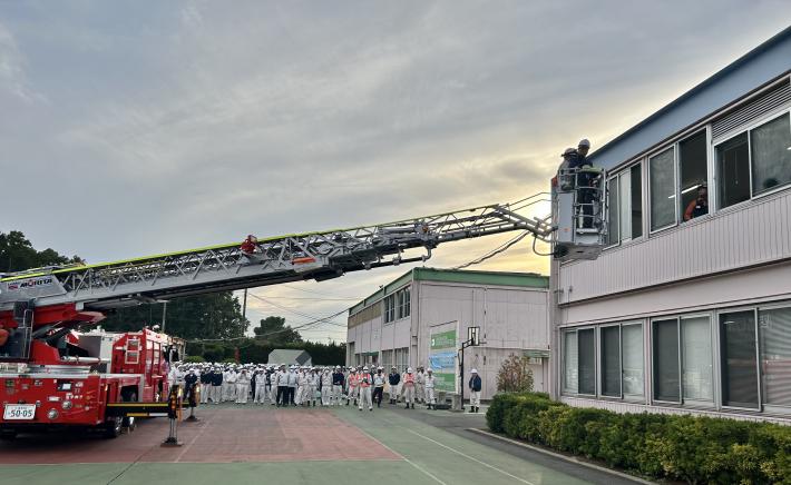 はしご車から伸びたはしごが、窓に差し掛かっている