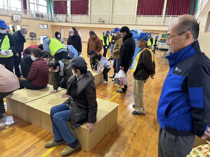 段ボールで作られたベッドに座る住民