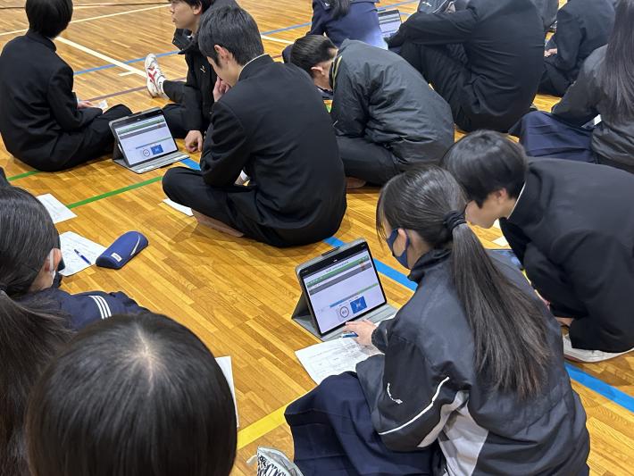 タブレット端末を指で操作する生徒たち