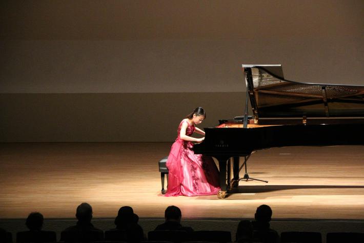 ドレスを着てピアノを演奏する女性