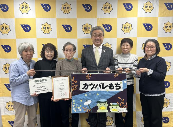 布絵本と表彰状をもってパネルの前に女性たち