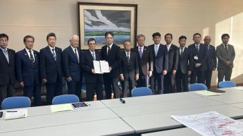 広い会議室内に横に並ぶ男女