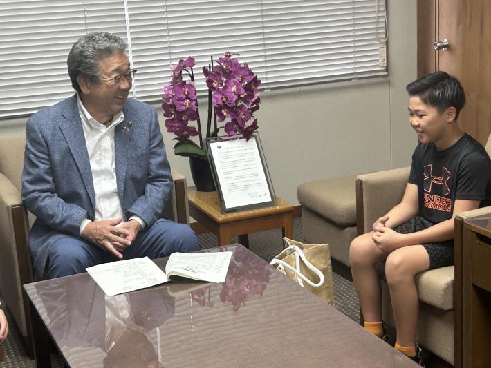 椅子に座って話をする小学生と男性