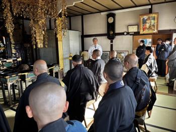 住職たちの前で挨拶をする男性