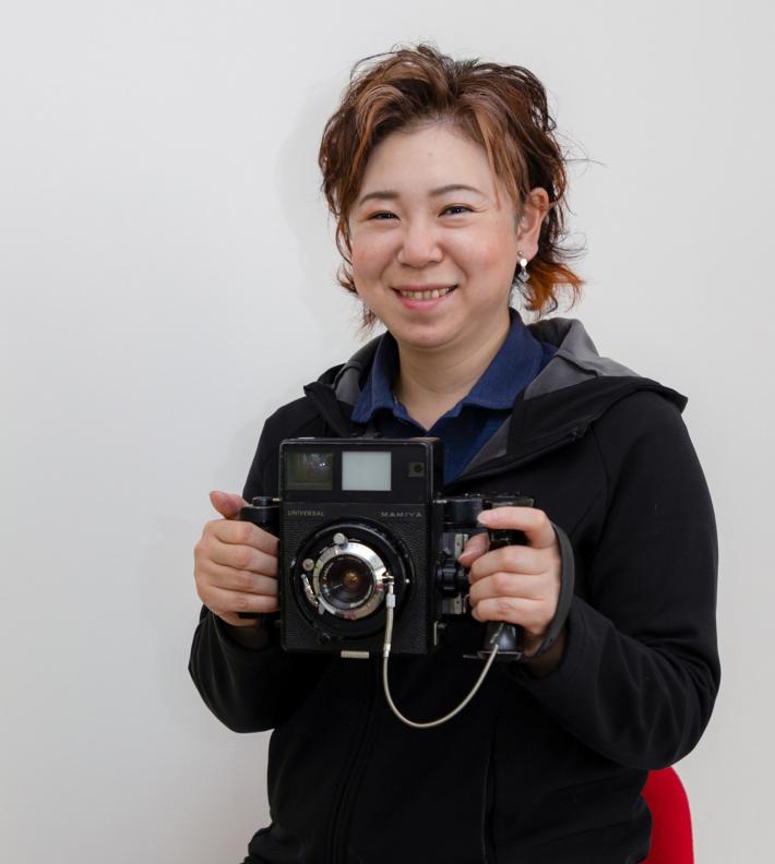 カメラを持って笑っている女性の画像