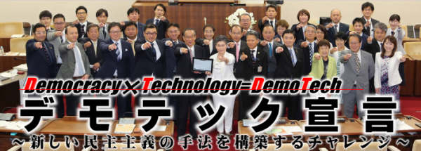 セレモニー参加者35人が手を前に出して写っている写真。「デモテック宣言、新しい民主主義の手法を構築するチャレンジ」