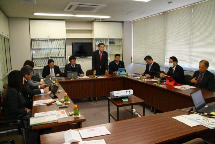 コの字型に並んだ議員立の中央の席で、同席した皆さんに対しあいさつする富士宮市の深澤議会運営委員長