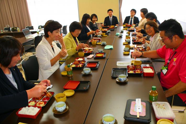 議会職員と議員、視察団が対面形式で着席。一緒にランチを食べながら、ミーティングを行っている写真。