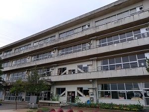 灰色のコンクリートでできた4階建ての学校の様子