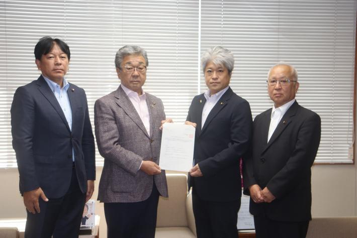 4人の男性が横並びに立って並んでいる