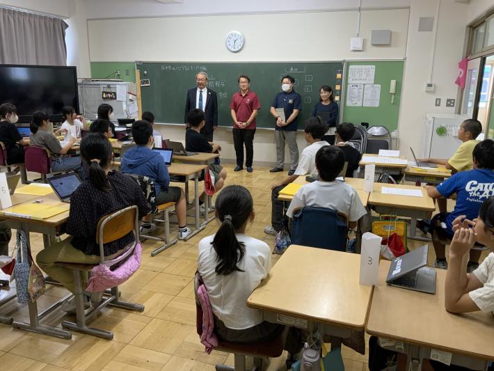 教室で議員が立って話しているのを生徒が座って聞いている