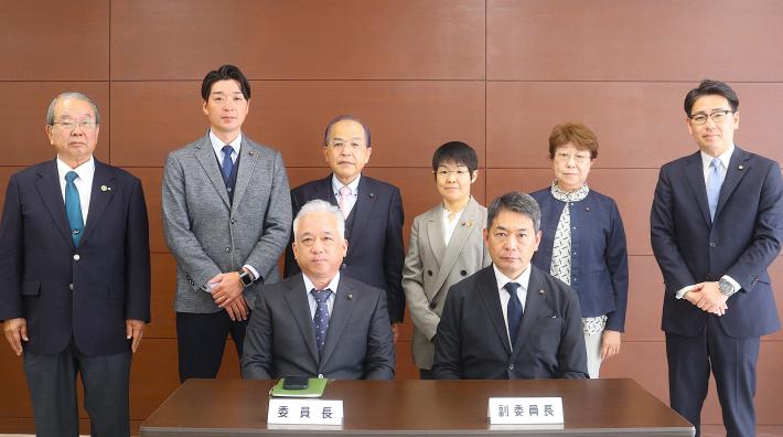 男性と女性の議員が前列は座って、後列は立っている