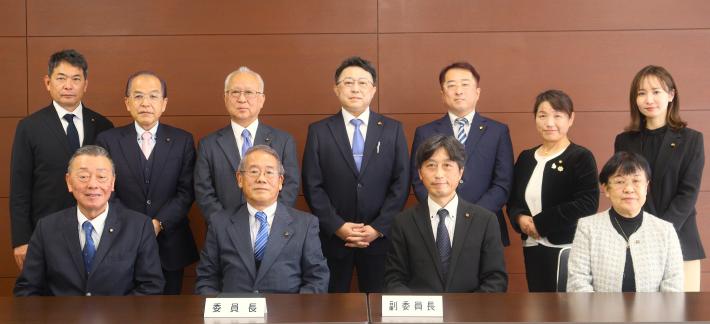 男性と女性の議員が前列は座って、後列は立っている