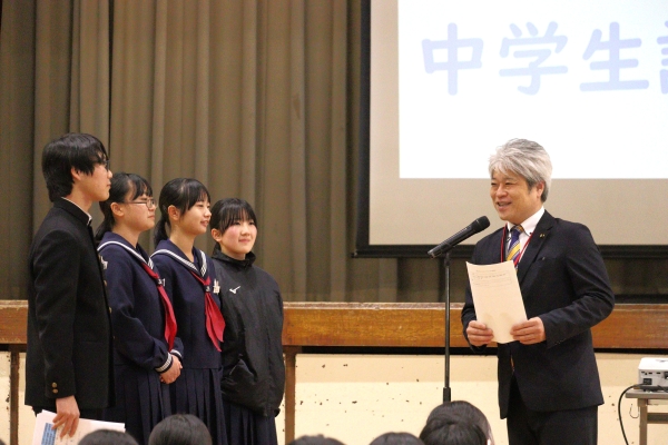 可決議案を中学生から受け取る山野井議長