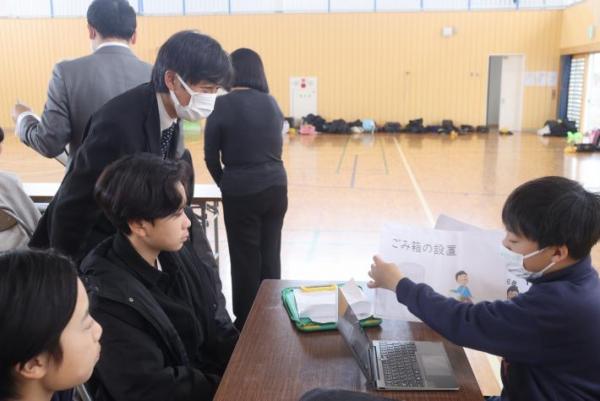 小学生の発表を聞く男性市議