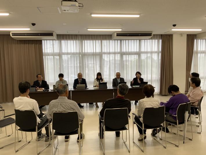 会議室で、男女数名の議員と市民数名が椅子に座って話をしている