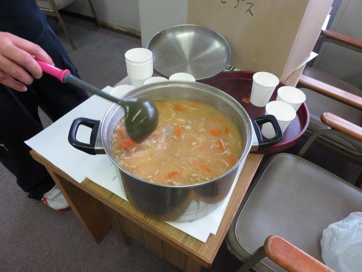 銀色の鍋が机上に置かれ、中に茶色い味噌汁が入っている。