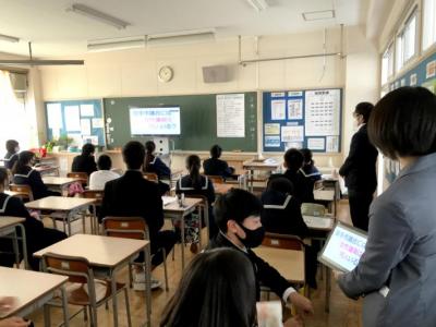 学校教室の黒板前にモニターが置かれている。生徒は自席に着席し、モニターに映る議会クイズを解いている。