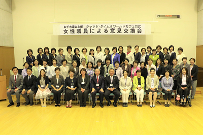 県内等女性議員による意見交換会集合写真。最前列は着席して、中列は立って、最後列は壇上で立ち笑顔で映っている。