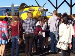 学生たちがホストファミリーと一緒に農業用のセスナ飛行機を見学している画像。