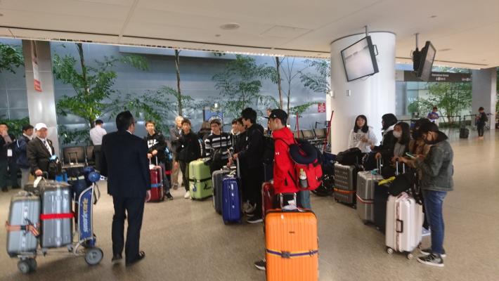 空港のロビーでスーツケースとともに待機をする派遣団員