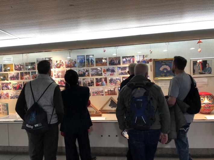 ガラス越しに展示されている写真や記念品を見るユーバ市民