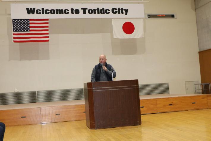 演台の前であいさつをするユーバ市長。ステージ上の看板には「welcome to toride city」と書かれている。