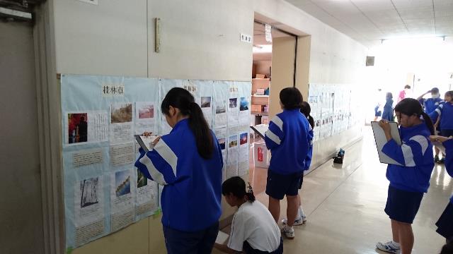バインダーを片手に廊下に掲示してある桂林市学生の作品を鑑賞する藤代南中学校学生