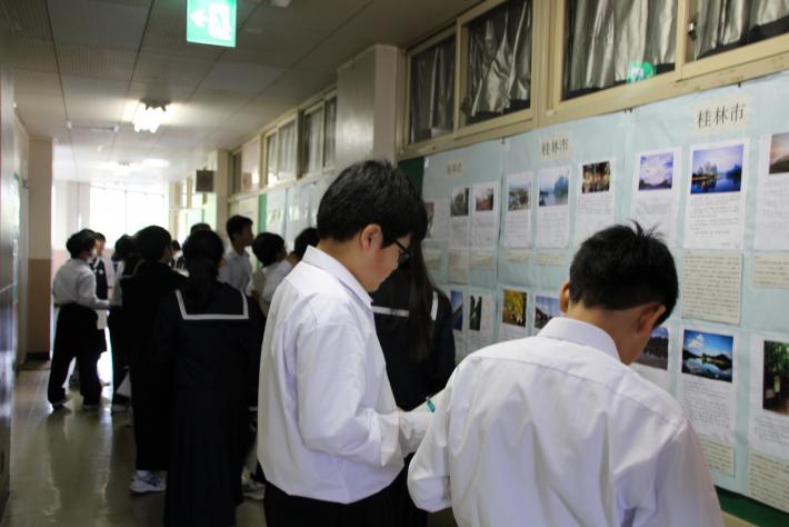 廊下に掲示された桂林市の学生の作品を鑑賞する永山中学校学生