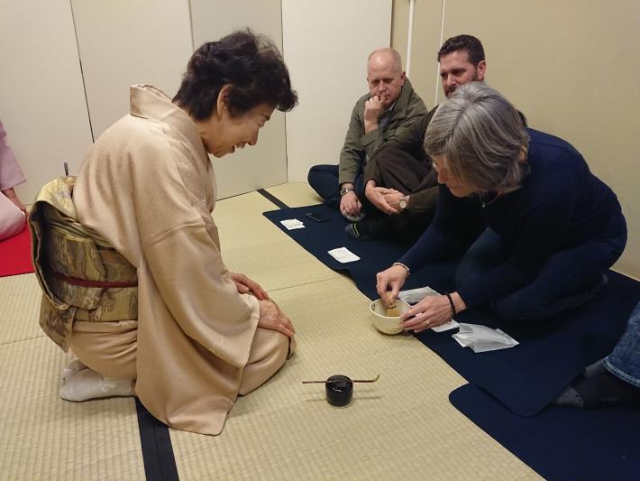 お茶をたてるユーバ市民とそれを見ている着物を着た日本人女性