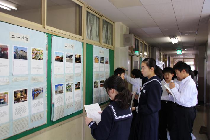 廊下に掲示されたユーバ市の学生の作品を鑑賞する永山中学校学生