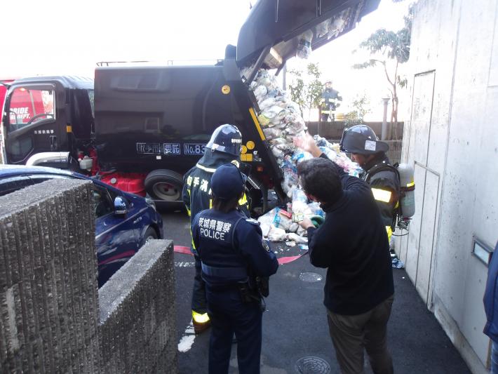 消防と警察が火災現場の調査を行っている