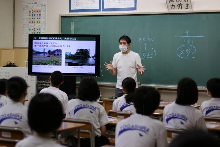 杉浦先生が生徒に地球温暖化と気候変動による影響を教壇で説明している様子