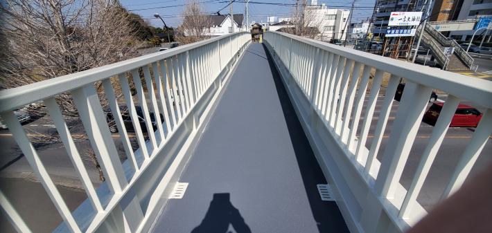 横断歩道橋を上から施工後の写真。錆がとれて新しく塗装されている。見た