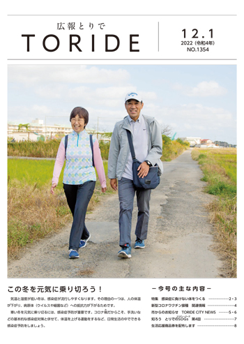 広報とりで12月1日号表紙。笑顔の夫婦が並んで農道を歩いている写真。
