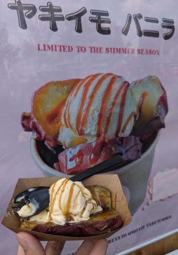 「さつまいもバニラ」の看板の前で撮影したサツマイモにバニラアイス・黒蜜ののった手持ちのデザート画像