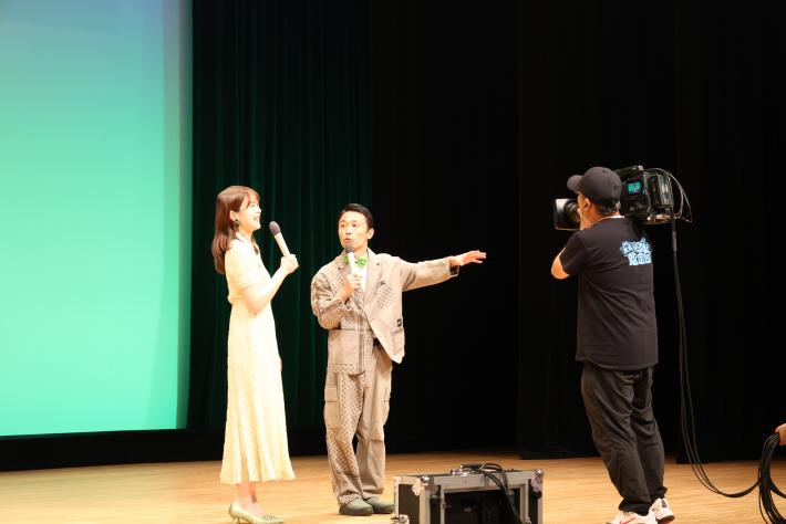 カミナリたくみさんとアシスタント吉川七瀬さんがステージに登場した様子