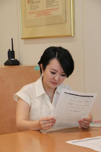  若い女性が紙を読み込んでいる写真