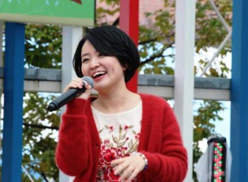 若い女性がマイクを片手に歌っている画像