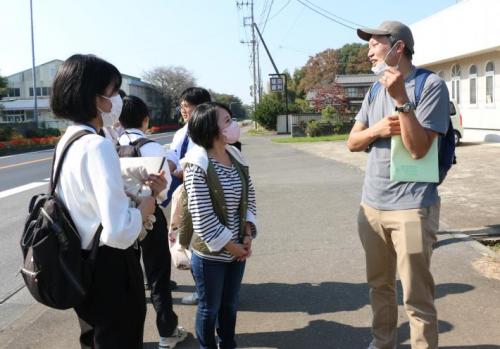 バス停のそばで話をしている若い女性と年配の男性