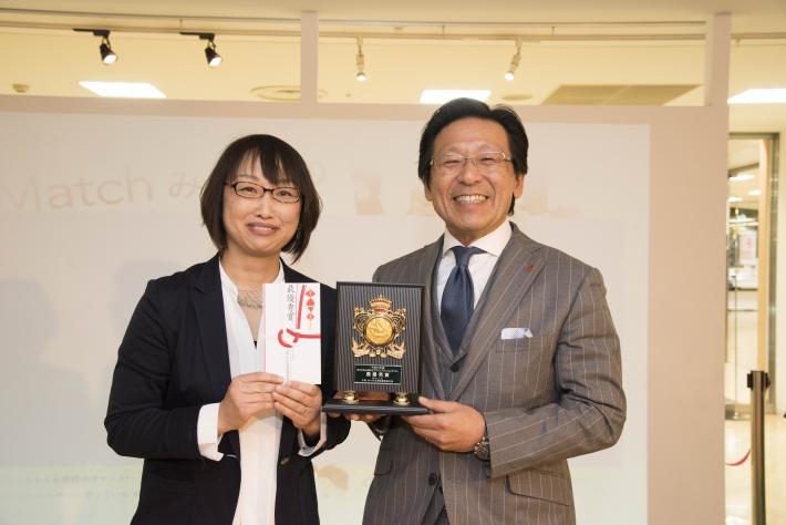 塚本審査委員長と賞の封筒を手にした二重作亜紀さんが並んで記念撮影。
