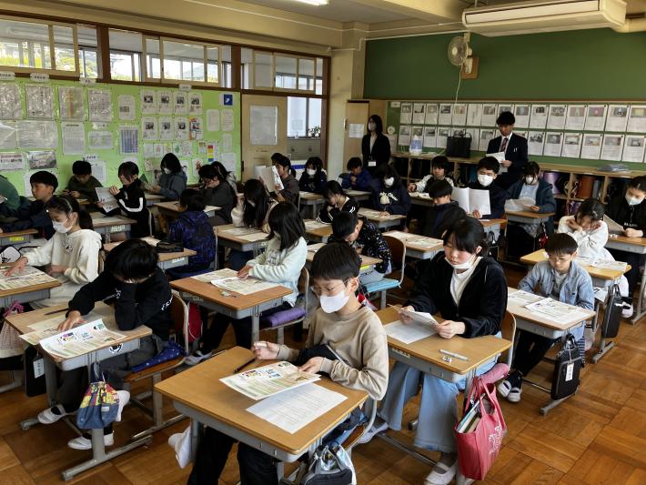 配布された資料を真剣なまなざしで読む児童たち